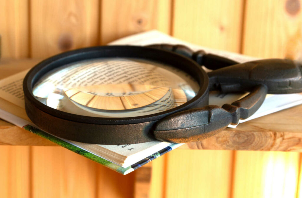 A magnifying glass used as a low vision aid to magnify the text for the person reading.
