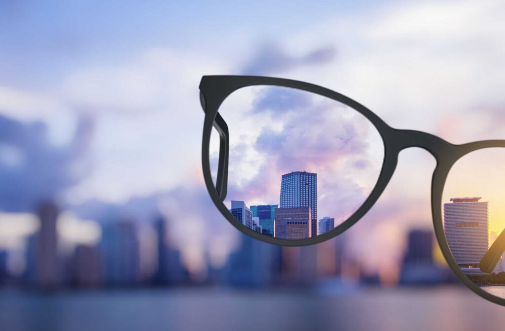 Blurry distance vision of a skyline with a clear view through the lens of a pair of glasses
