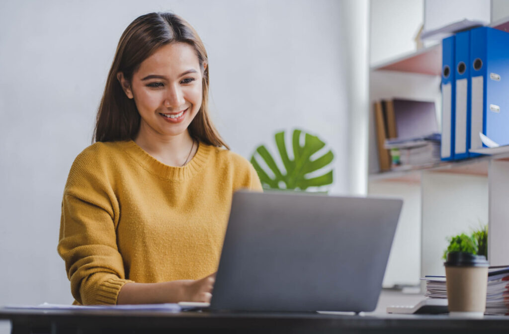 Young woman using her laptop in a sufficiently bright room and with the screen at the recommended distanc